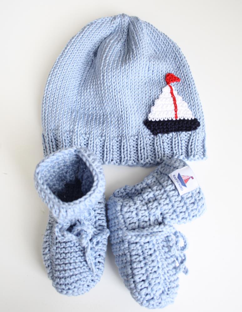 Handgestrickte Mütze und Schuhe mit Segelboot